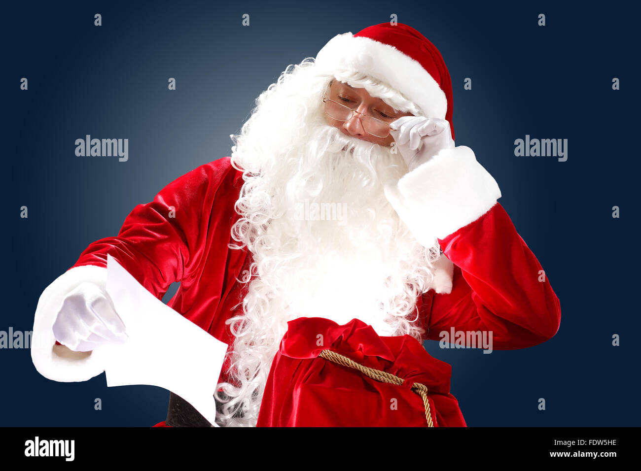 Santa Claus holding and reading a letter to him Stock Photo - Alamy