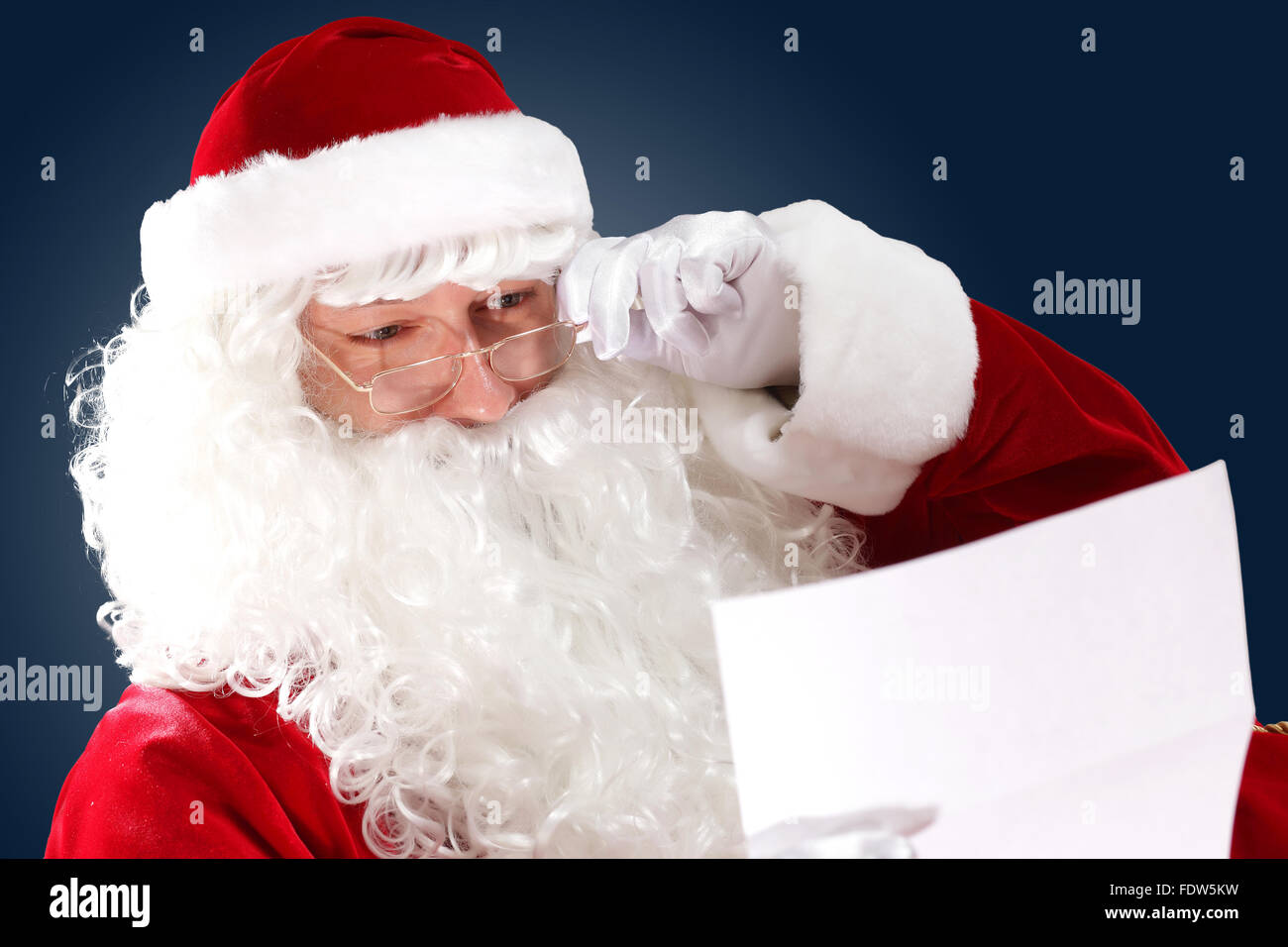 Santa Claus holding and reading a letter to him Stock Photo - Alamy