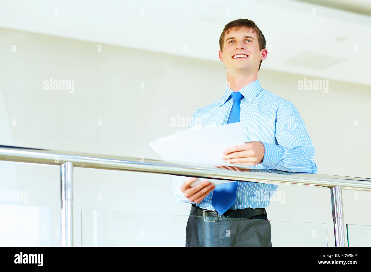 Portrait of happy smiling young businessman, standing in office Stock ...