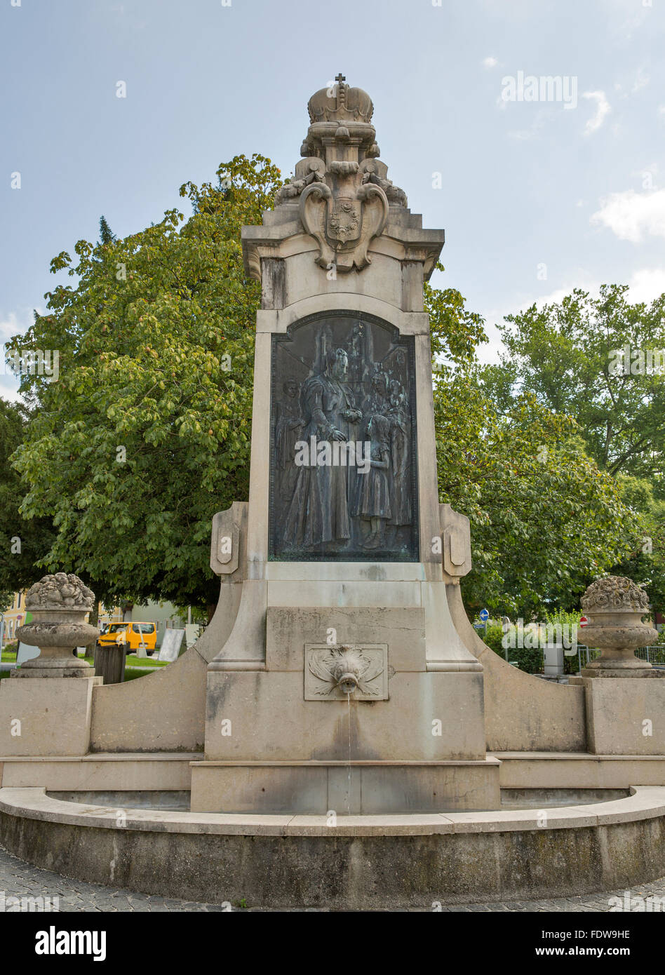 Religious monument with fountain near St. Michael Basilica (formerly Collegiate Church) at Mondsee, Austria. Stock Photo