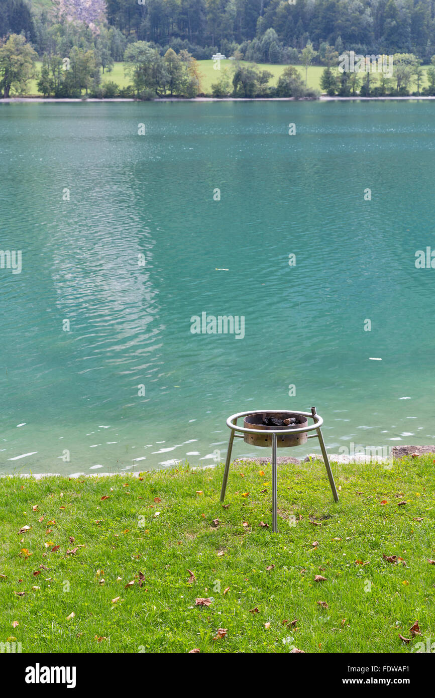 small round metal grill on the lawn for barbecue on the shore of the  mountain lake Mondsee, Austria Stock Photo - Alamy