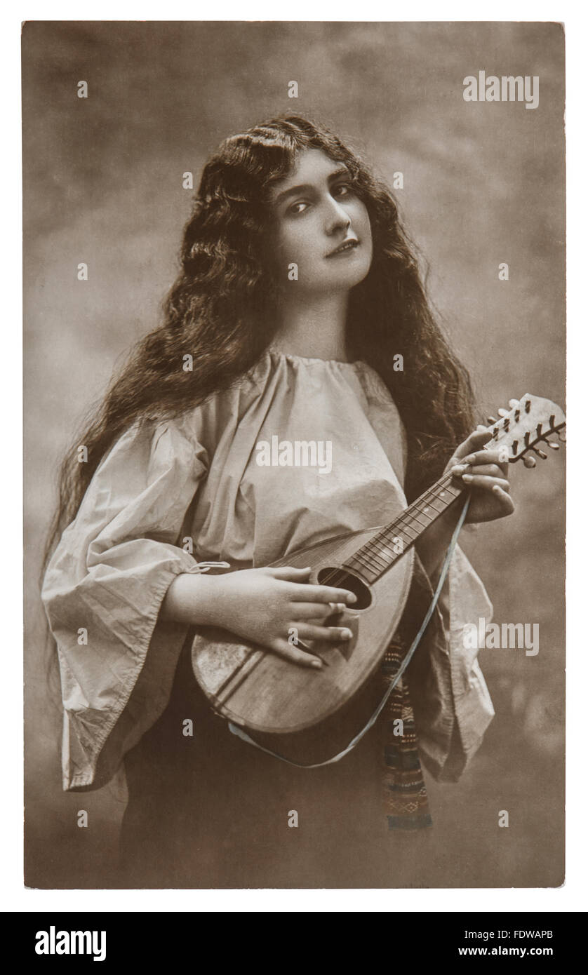Beautiful young girl with mandolin. Vintage picture with original film grain and blur Stock Photo