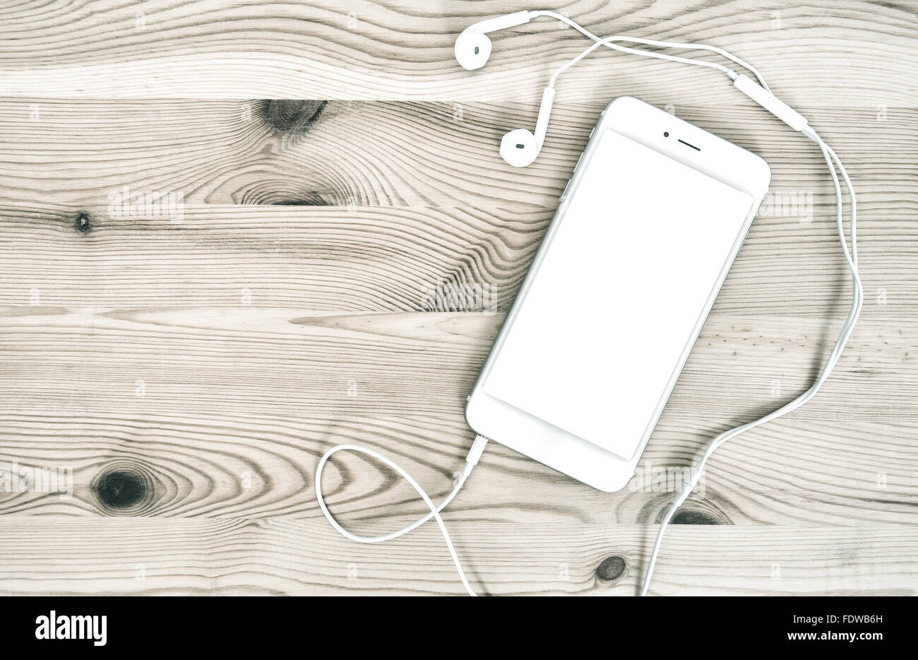 Digital phone with headphones on wooden background Stock Photo