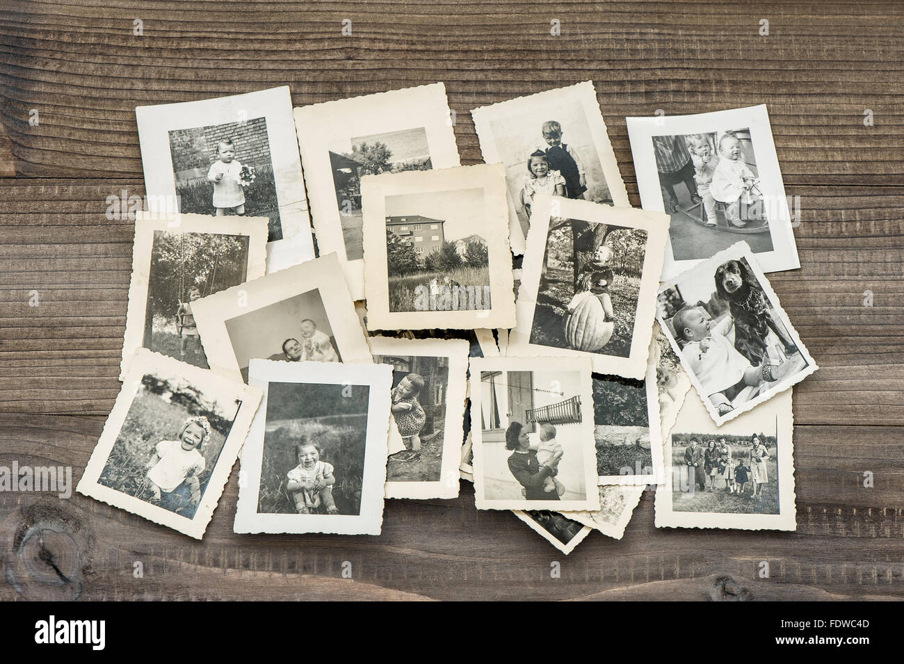 Old family photos on wooden table. Vintage pictures Stock Photo