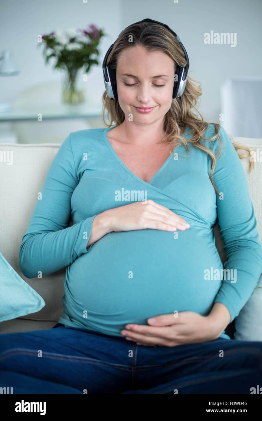 Pregnant woman listening to music Stock Photo - Alamy