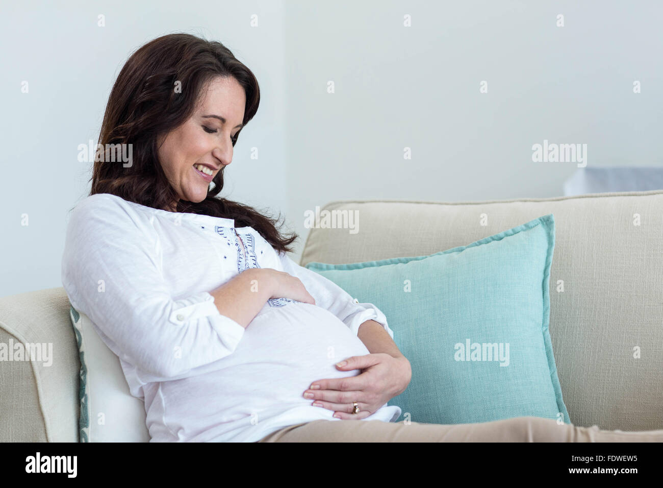Pregnant woman resting on couch Stock Photo Alamy