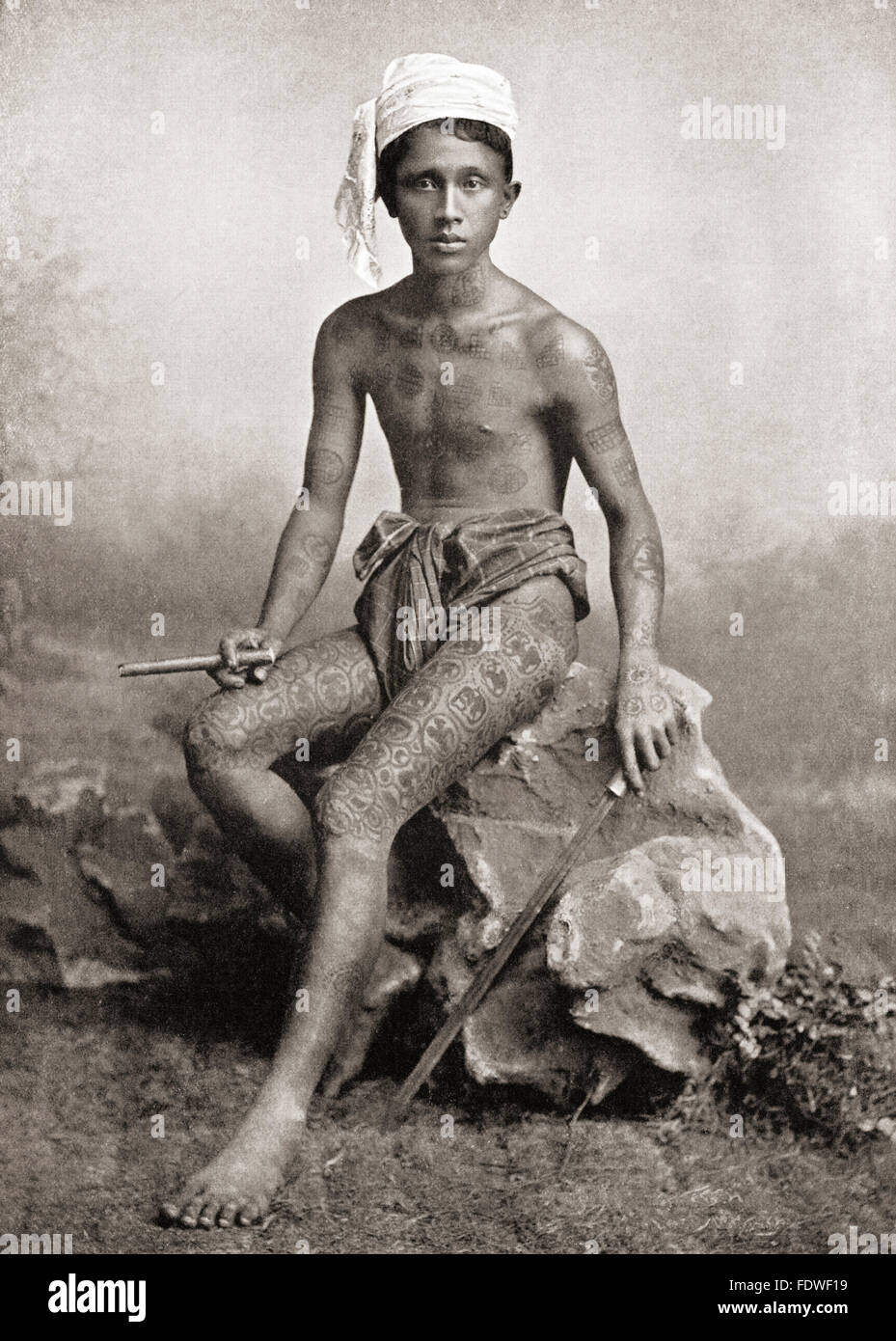 Burmese tattooing.  Most Burmese were tattooed in blue from the waist, about the top of the loin cloth to the knee.  The figures of tigers, ogres etc were encircled with scroll lettering. The tattooing of the body and arms was in red and was intended to secure immunity from sword or gunshot wounds, or success in love.  After a 19th century photograph. Stock Photo