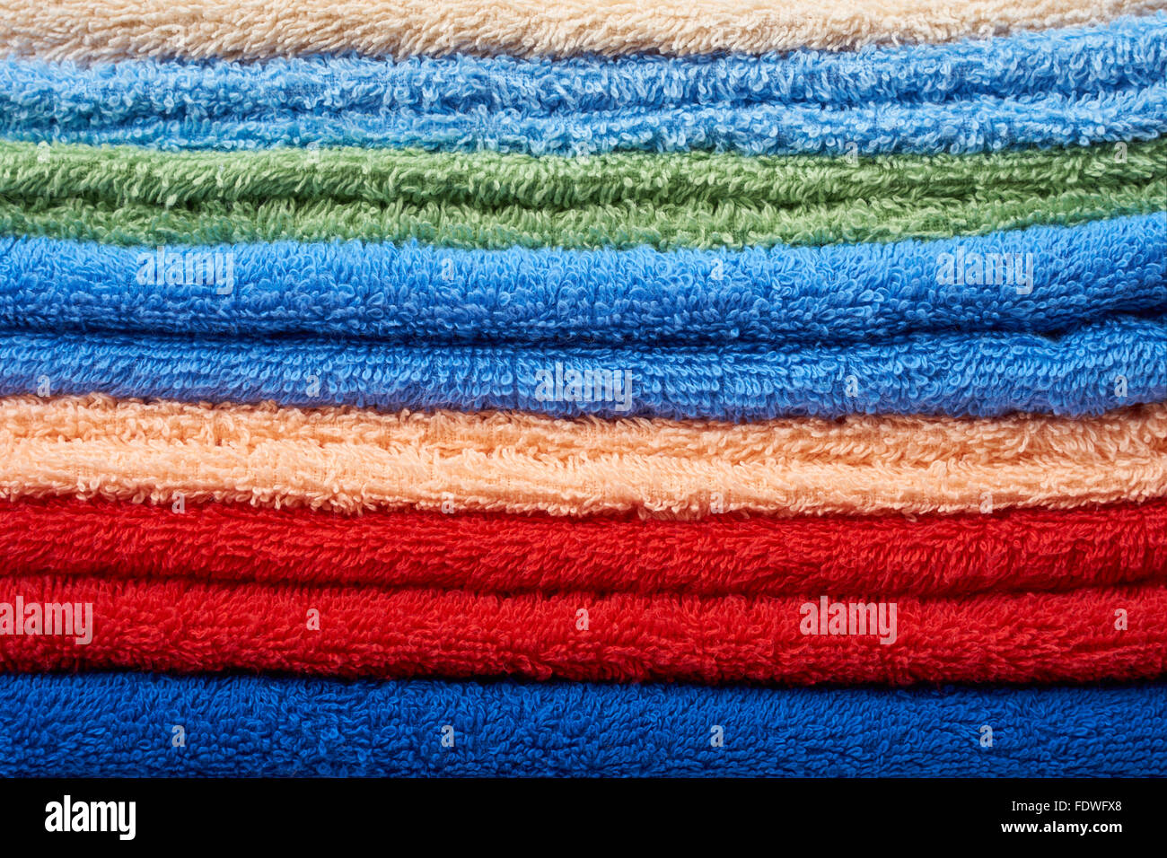 Many multicolored terry towels background: blue, red, pink and beige Stock Photo