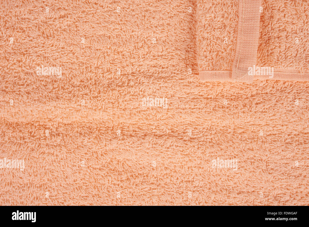 Beige terry towel as a background with one corner Stock Photo