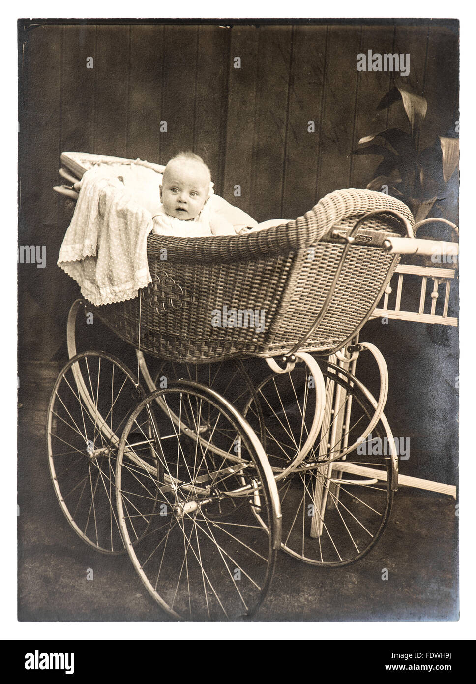 Cute baby in vintage buggy. Vintage picture with original film grain, blur and scratches Stock Photo