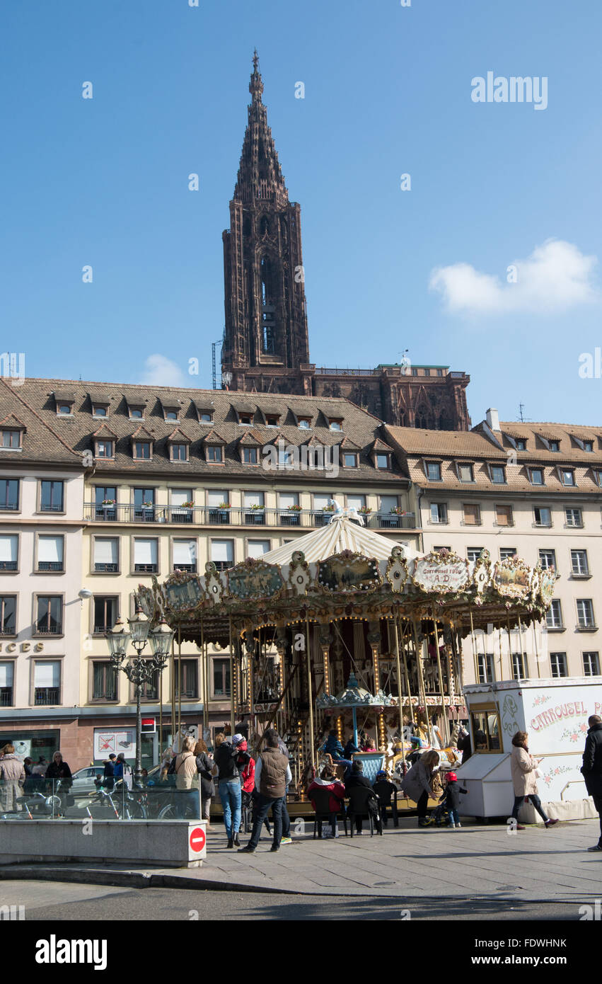 A vintage fairground roundabout from in Place Gutenberg Strasbourg . The tower of the Notre Dame cathedral is in the background Stock Photo