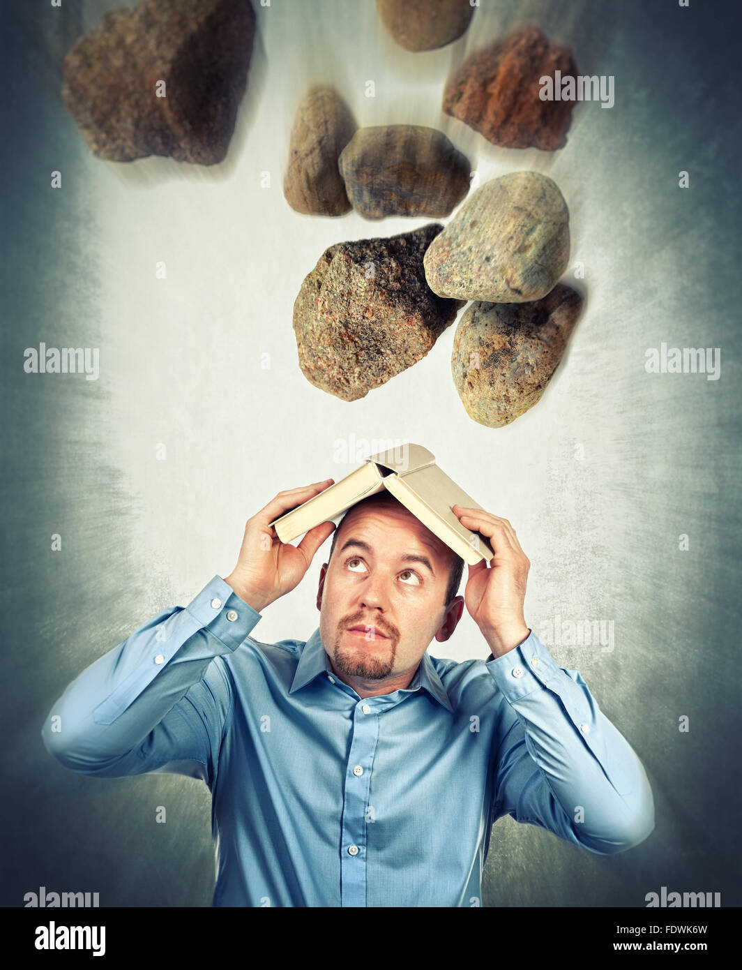 falling stone and man with book Stock Photo