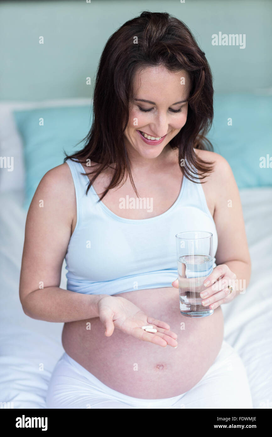 Pregnant woman taking a pill with water Stock Photo Alamy