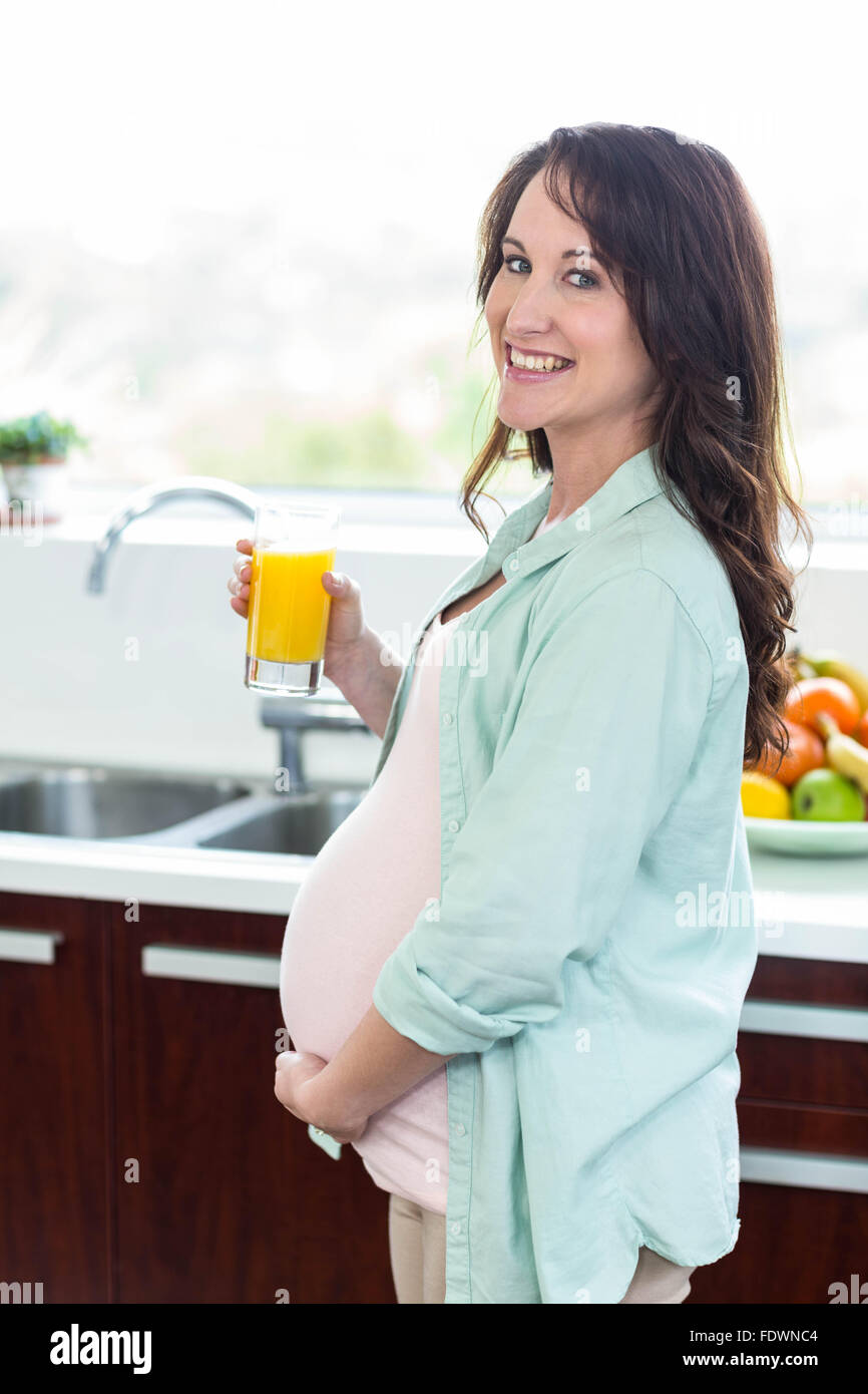 Pregnant woman holding orange juice Stock Photo Alamy