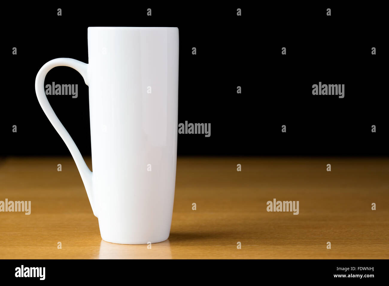Tall white mug on a wooden table Stock Photo