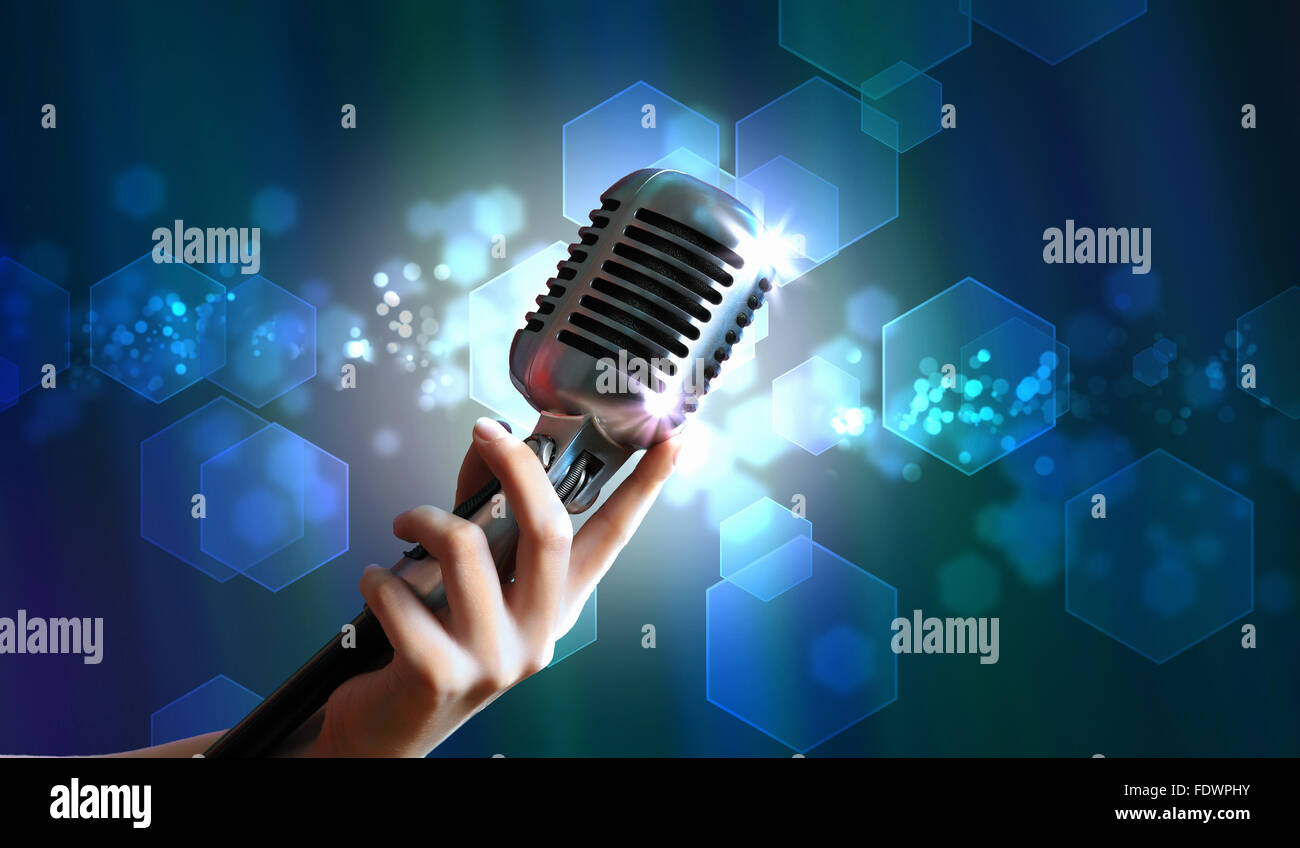 Single retro microphone against colourful background with lights Stock Photo
