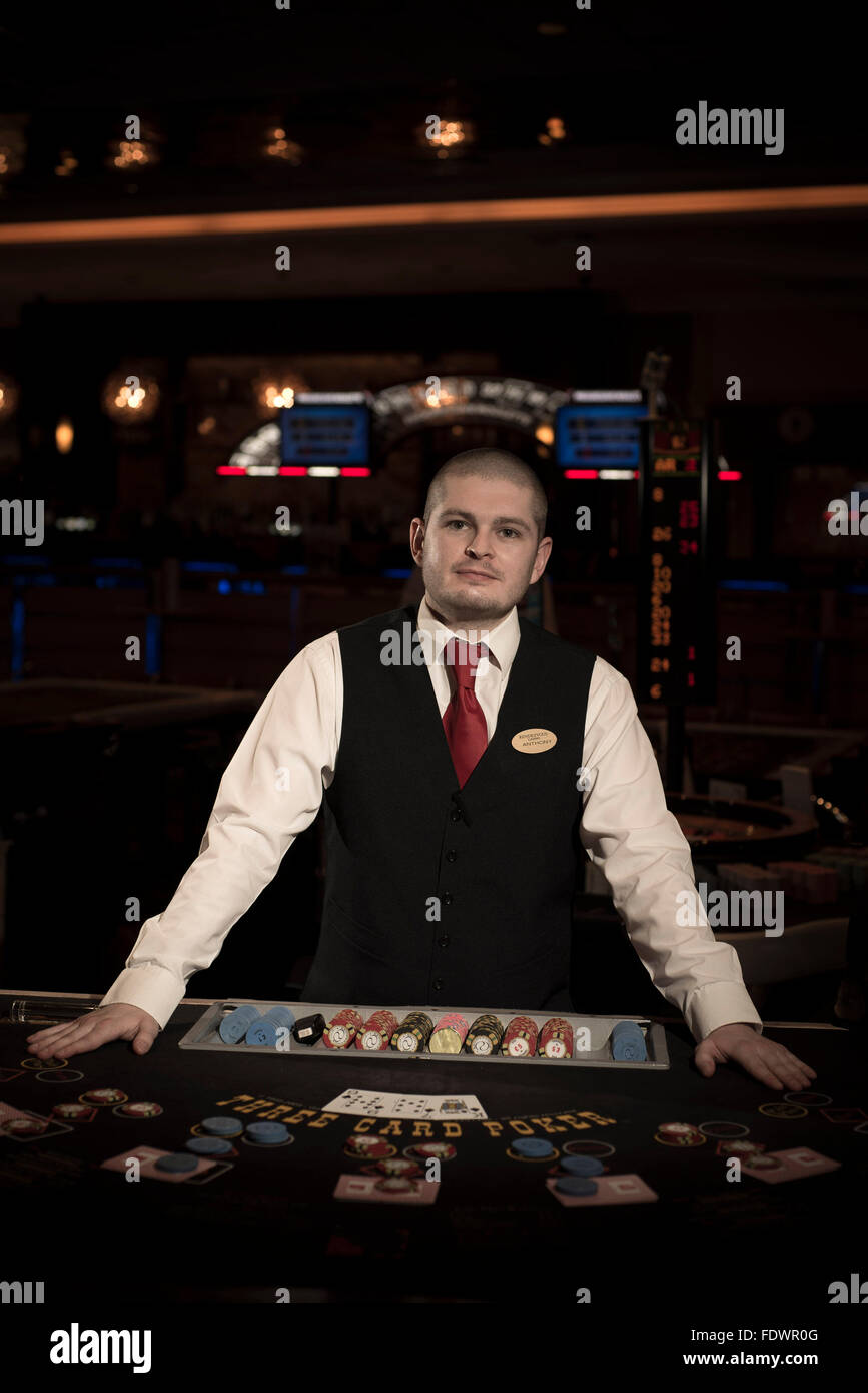 a croupier poses for the camera at a casino ready for people to start  gambling with cards or on the roulette table Stock Photo - Alamy