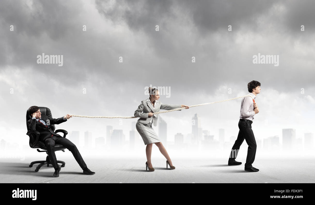 Pulling Against Rope Image of three businesspeople pulling rope against city background ...