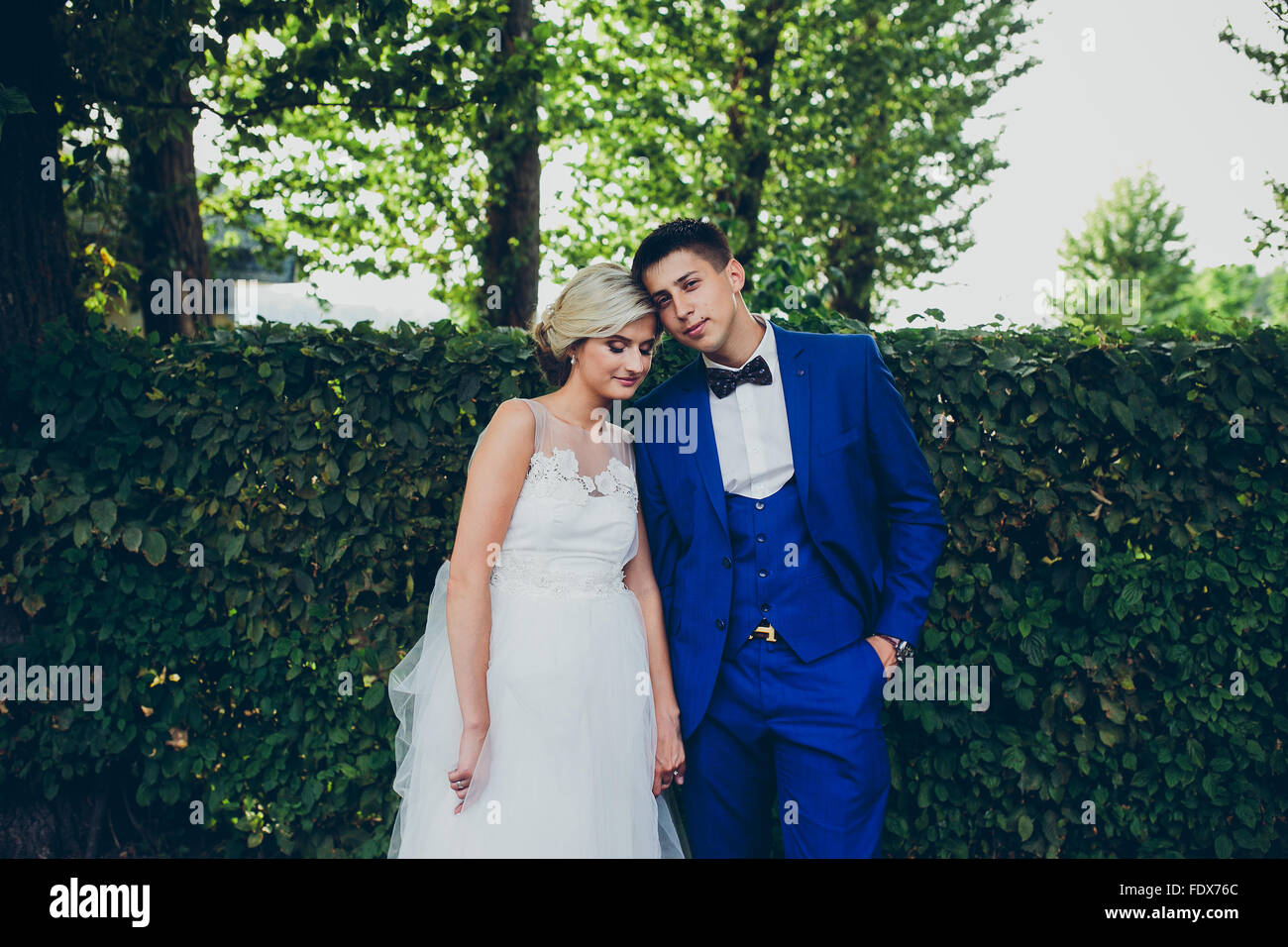 Beautiful wedding couple posing in the park Stock Photo - Alamy