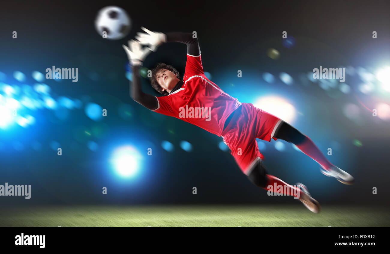 Goalkeeper catches the ball . At the stadium, in the spotlight Stock Photo Alamy