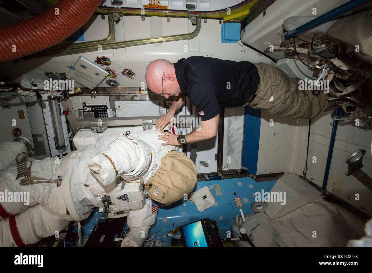 NASA astronaut Scott Kelly relocates spacewalk hardware and suits inside the Quest airlock aboard the International Space Station January 27, 2016 in Earth Orbit. Stock Photo