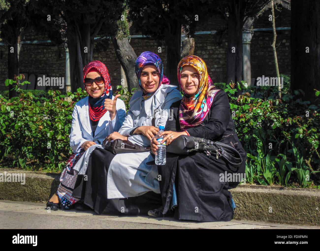 Three girls sitting with colourful headscarfs in Turkey. Stock Photo