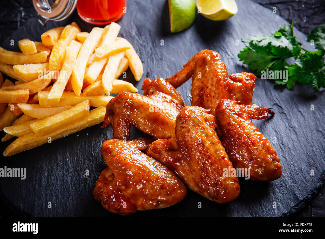 Fried chicken wings with potato on black stone Stock Photo Alamy