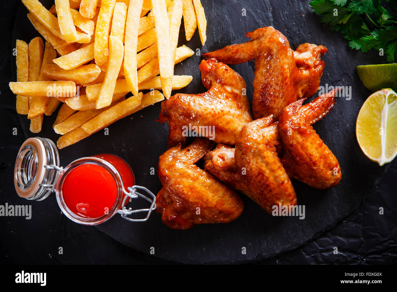 Fried chicken wings with potato on black stone Stock Photo Alamy