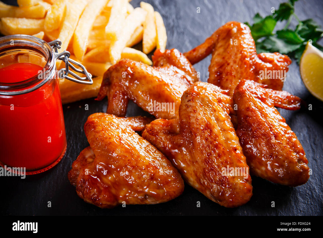 Fried chicken wings with potato on black stone Stock Photo Alamy