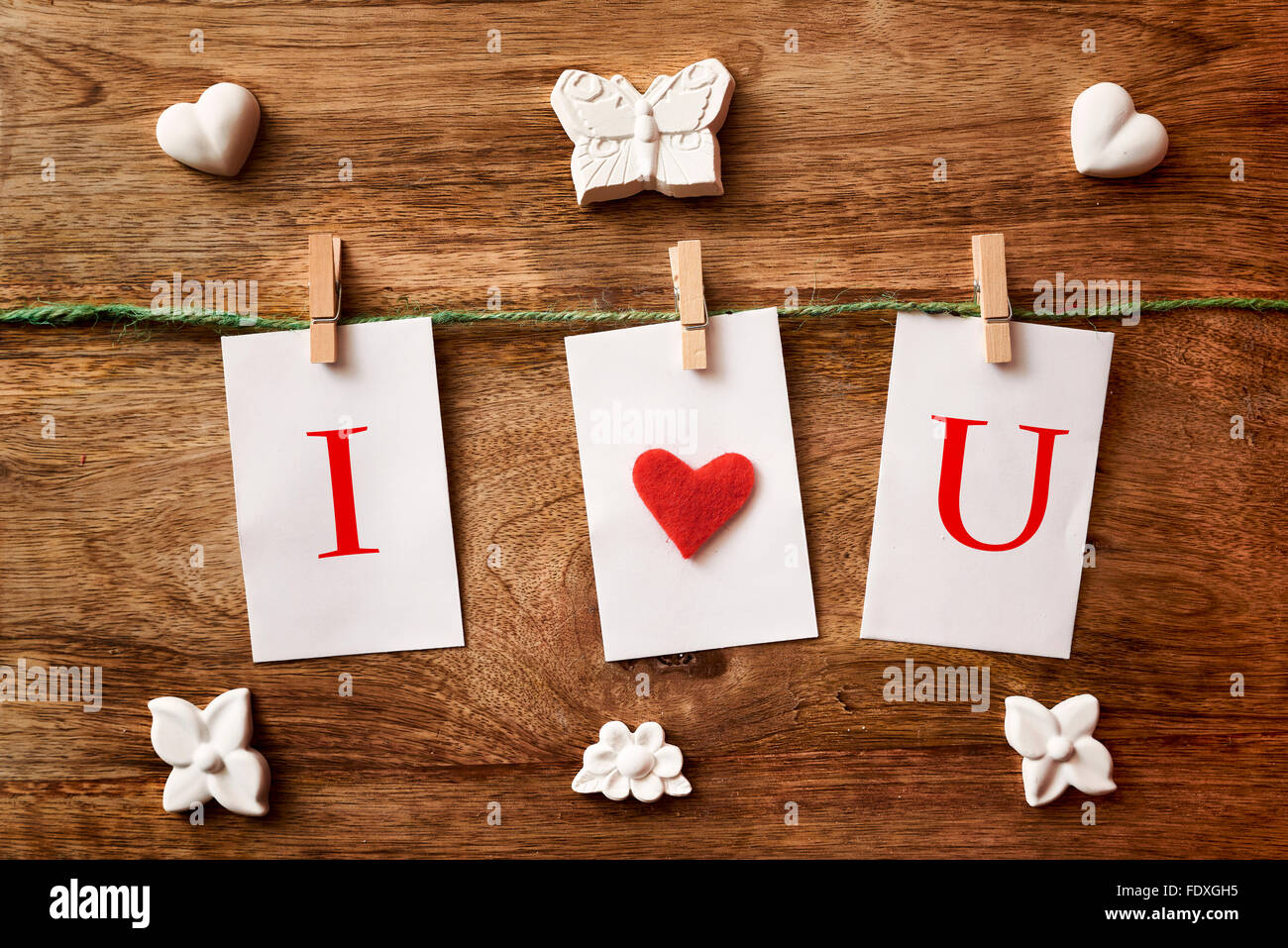 chalk heart, butterfly and flower, cord, three white paper, clothespins and cloth heart and i love you written Stock Photo