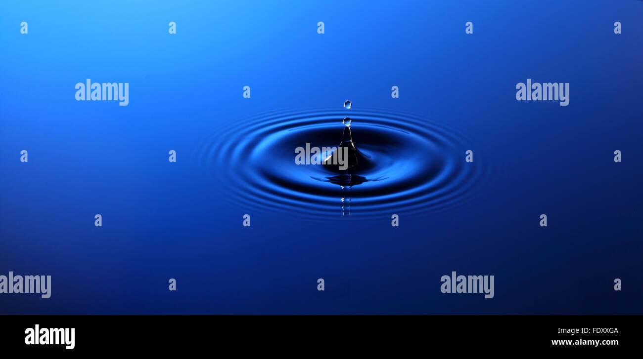 Drop of water falling into the water and leaving it circles Stock Photo