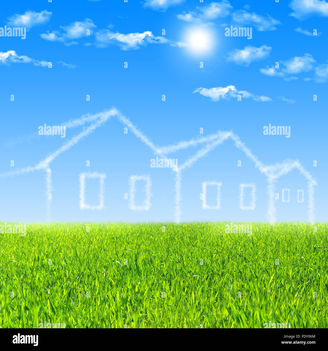 House of clouds in the blue sky against a background of green grass ...