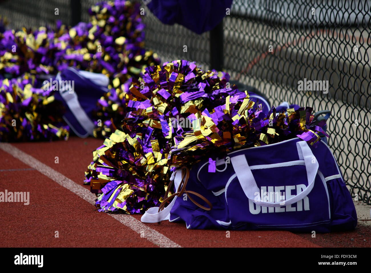 Close-up photograph of cheerleader bags with pom poms on tennis court Stock Photo