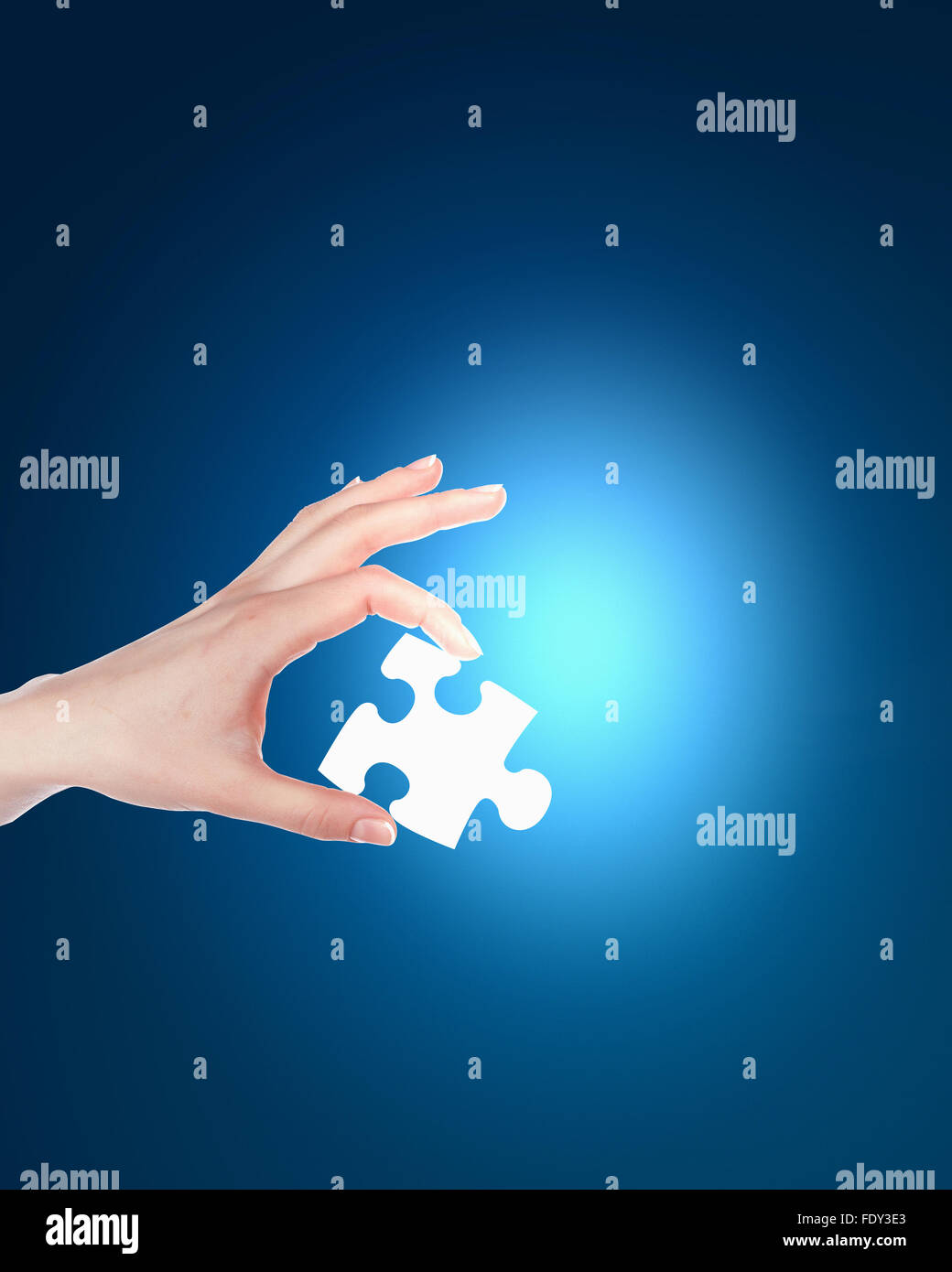 human hand with a blue shining piece of puzzle Stock Photo - Alamy