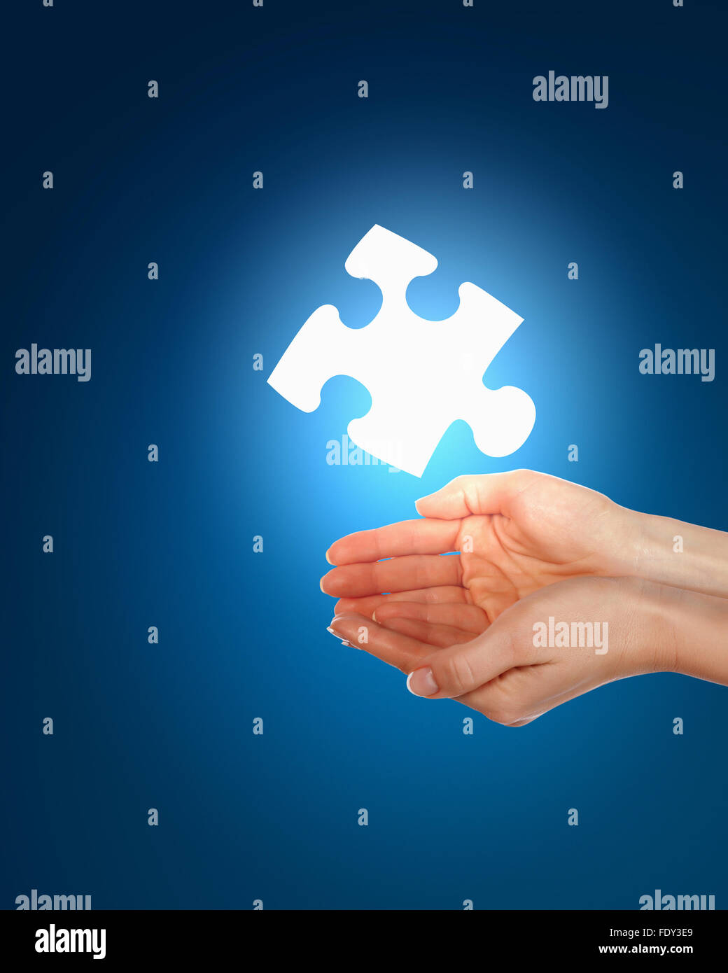 human hand with a blue shining piece of puzzle Stock Photo - Alamy