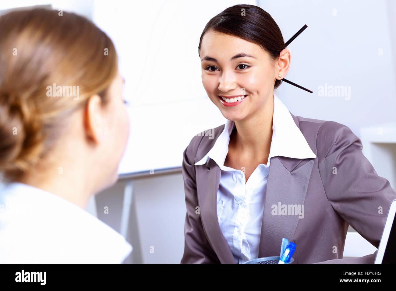 Young women in business wear working in office together Stock Photo - Alamy