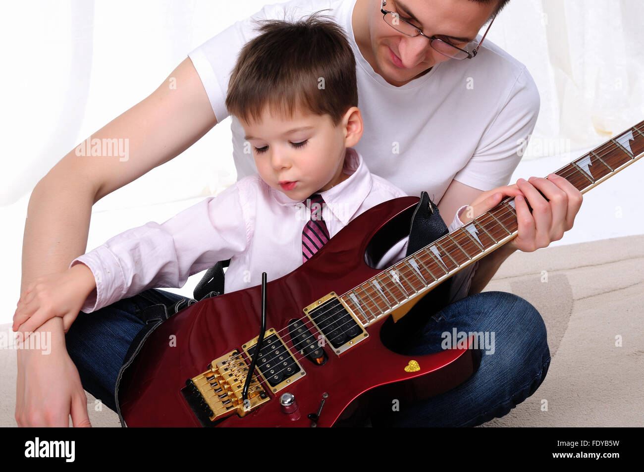 Научи папу играть. Картинка папа играет на гитаре. Отец учит ребенка играть на гитаре. Отец учит сына играть на гитаре. Фото папа и сын учатся играть на гитаре.