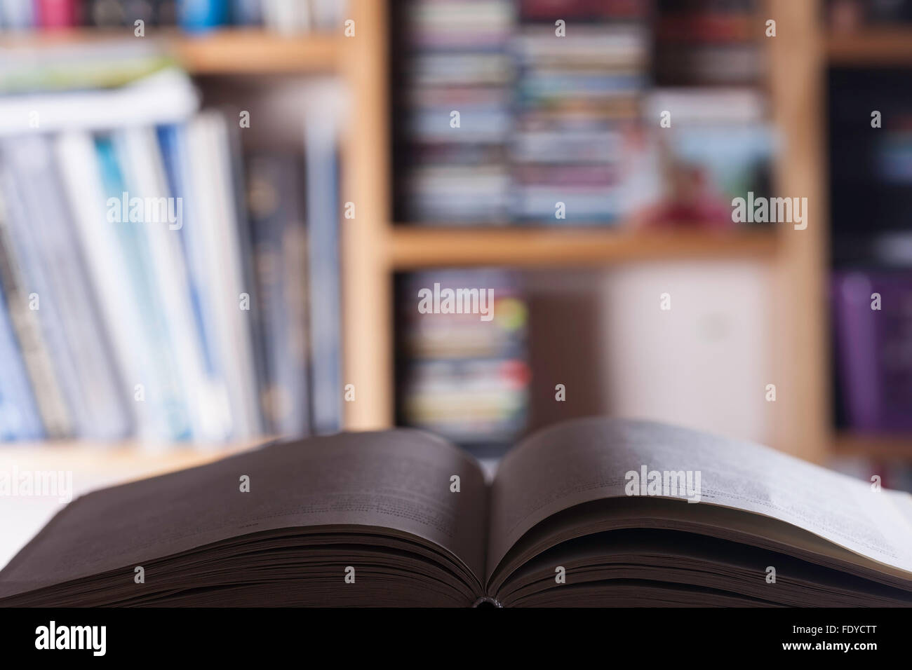 open book on the blured background of bookshelves Stock Photo