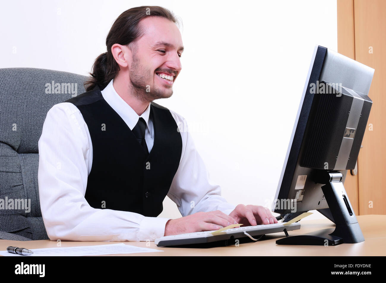 A young business man working on the computer in the office Stock Photo ...