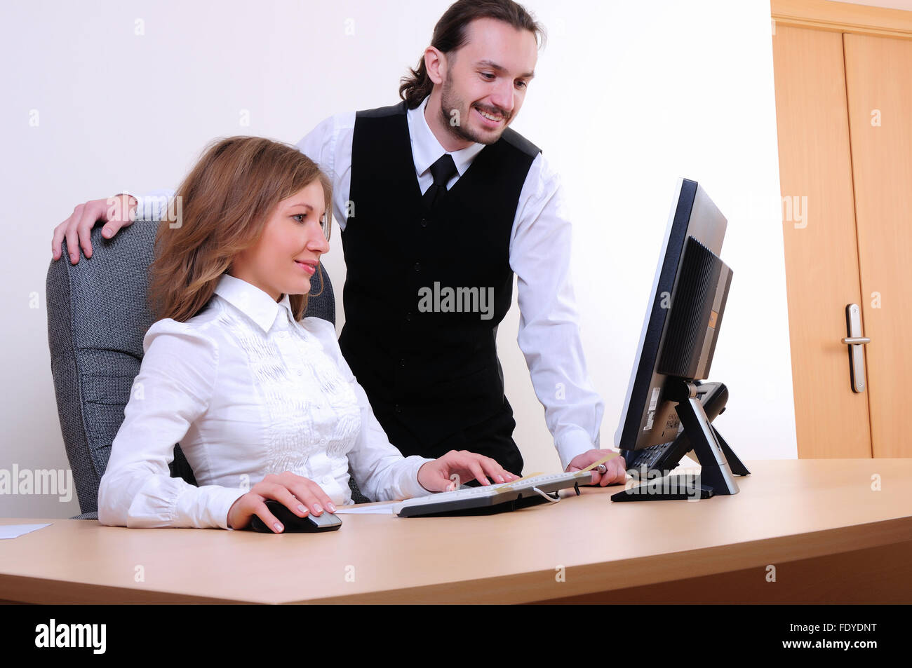 A young business man and a girl running on the computer in the office ...