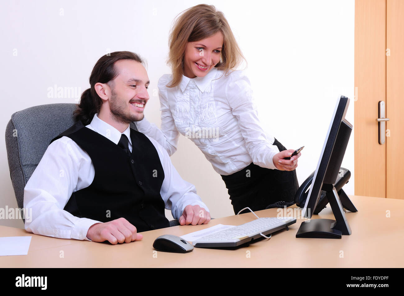 A young business man and a girl running on the computer in the office ...