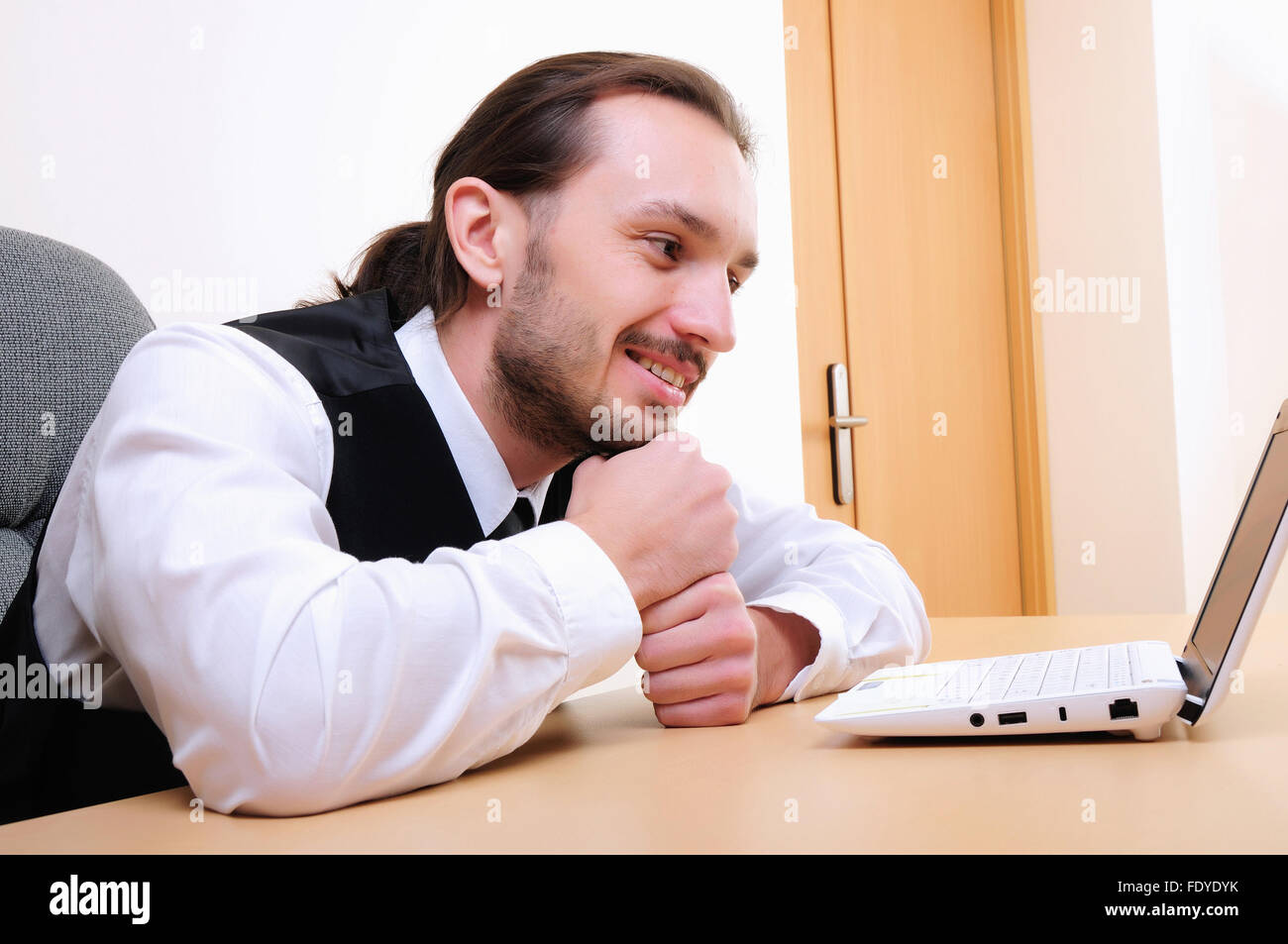 A young business man working on the computer in the office Stock Photo ...
