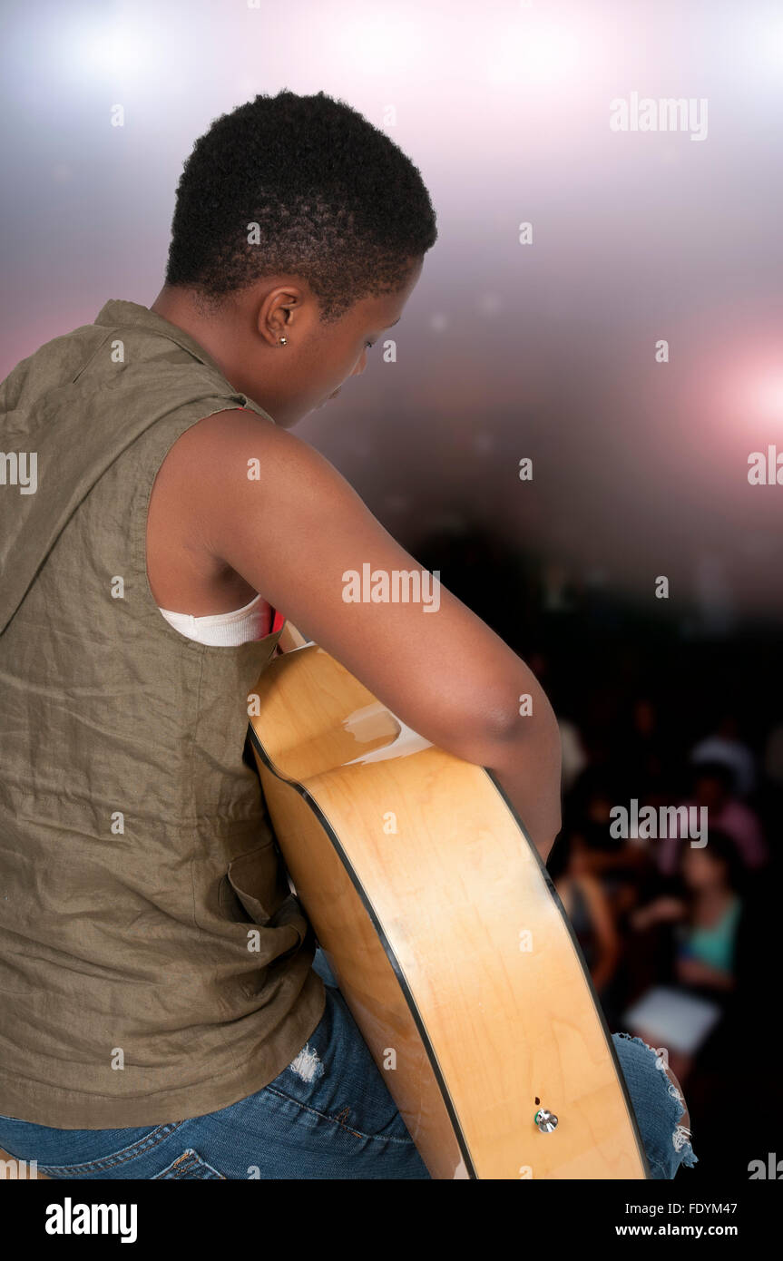 Beautiful young woman playing an acoustic guitar Stock Photo - Alamy