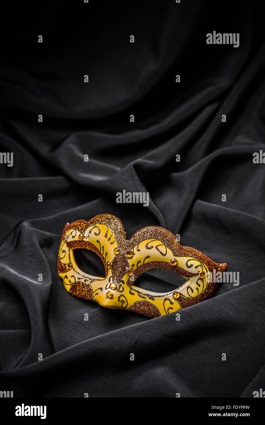 Yellow carnival mask on black background Stock Photo