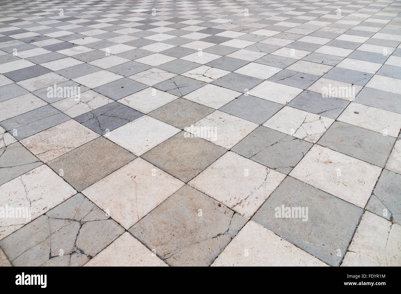 Old and partly cracked tiled floor, wide angle perspective view Stock Photo