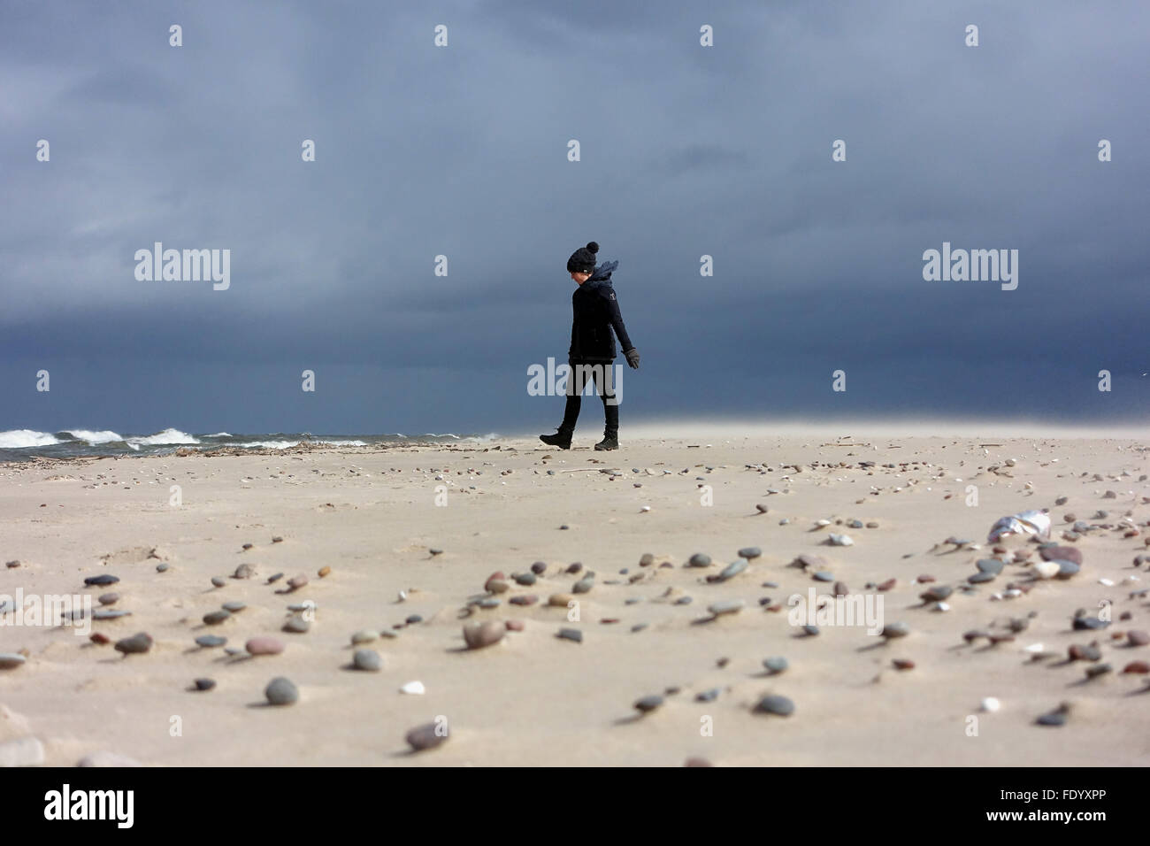 Kolberg, Poland, Woman runs in rainy weather alone along the beach Stock Photo