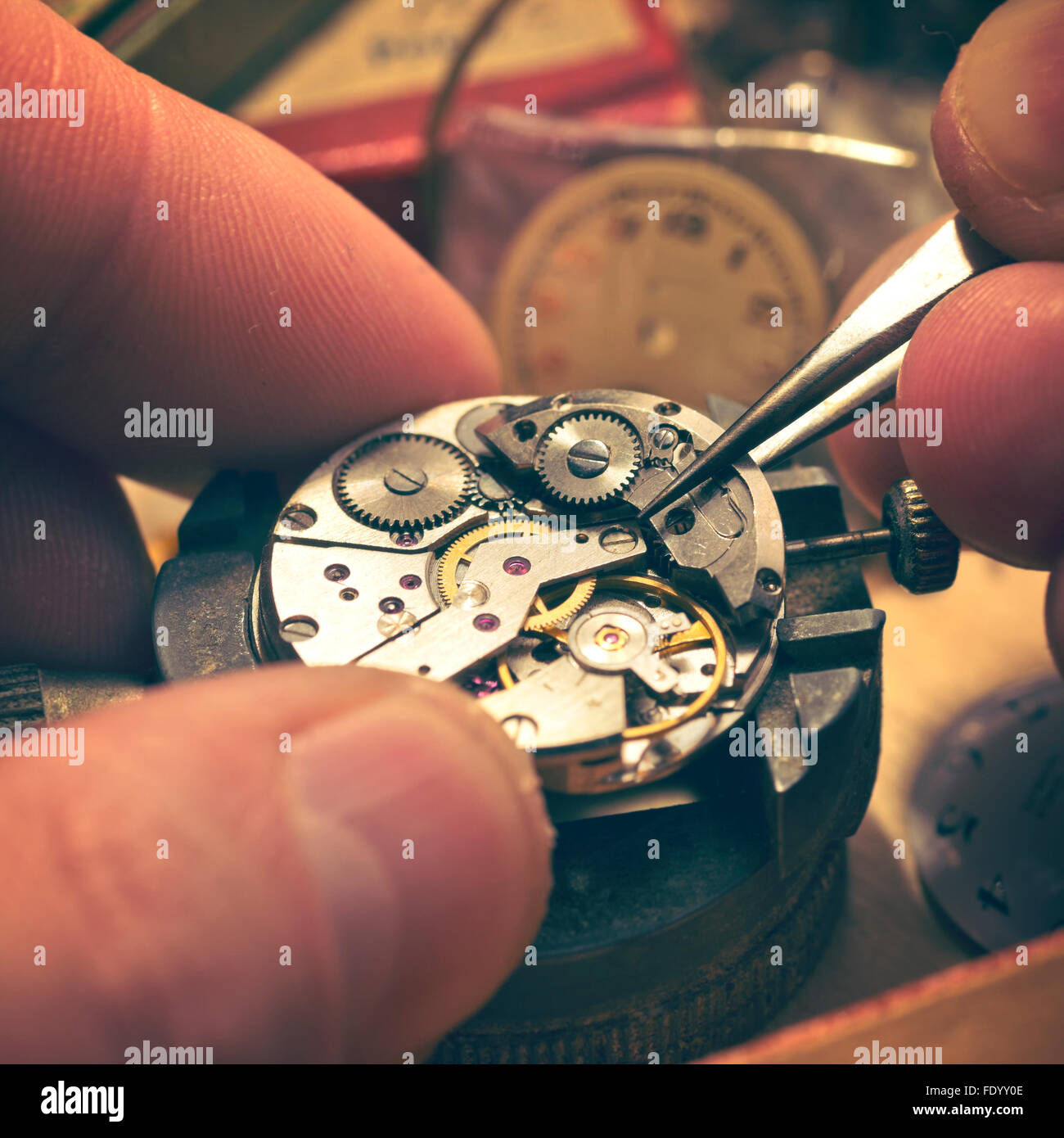 Working On A Mechanical Watch. A watch makers work top. The inside workings of a vintage mechanical watch. Stock Photo