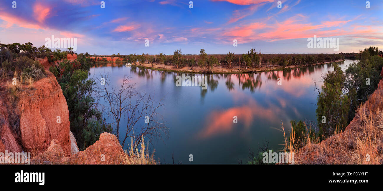 Panorama of still river water of Murray between elevated Victoria Red Cliffs and low NSW plains at sunset Stock Photo