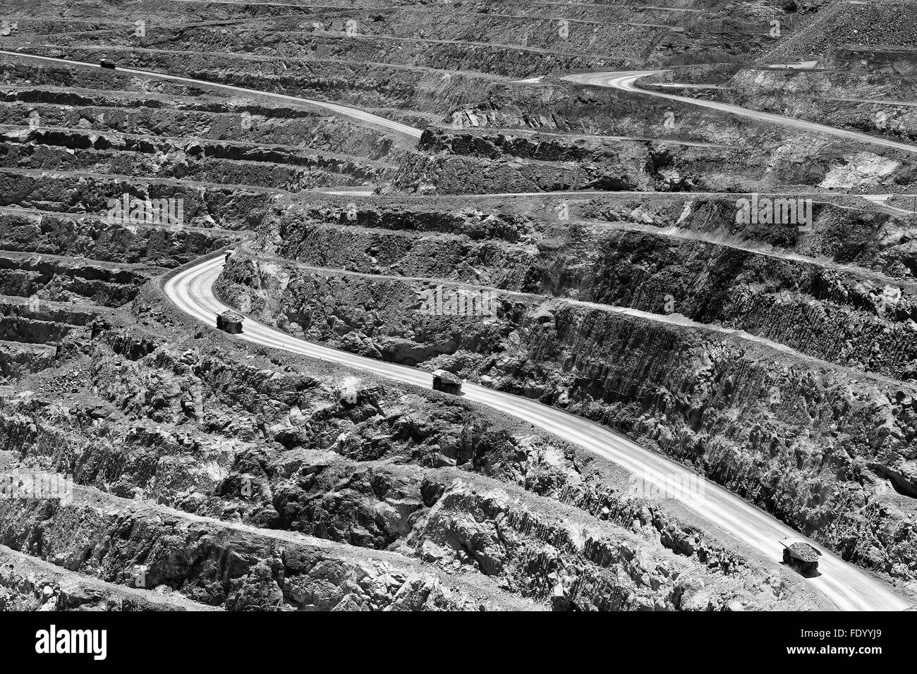 huge open pit gold mine in Western Australia Kalgoorlie Boulder town with industrial trucks loaded with ore ascending from pit's Stock Photo