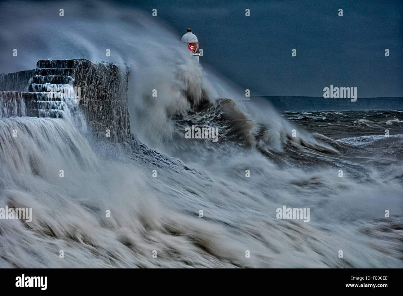 Storm Frank, Large waves collide into the sea wall as storm hits  Lighthouse, Porthcawl.  Bridgend, South Wales, UK Stock Photo